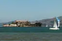 A sailboat passing Alcatraz Island on the bay