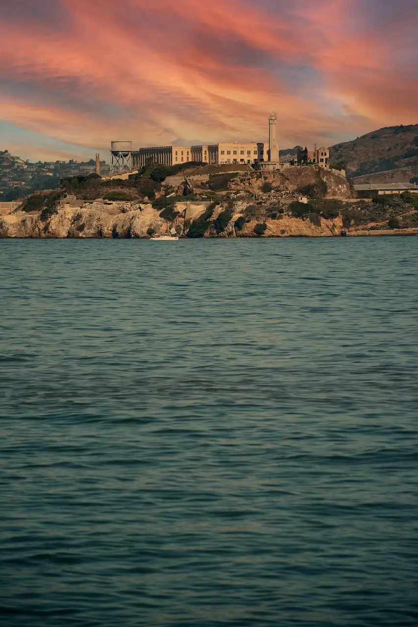 Alcatraz Island under a red sunset sky, seen across the bay