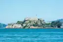 Alcatraz Island rising from blue bay water on a sunny day