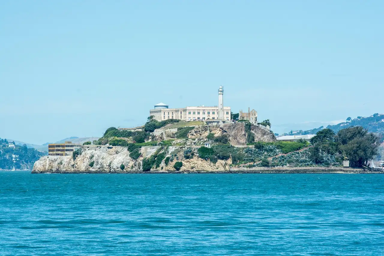 Alcatraz Island rising from blue bay water on a sunny day