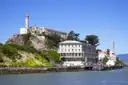 Alcatraz Island seen from the water: the dock, the old buildings and the lighthouse