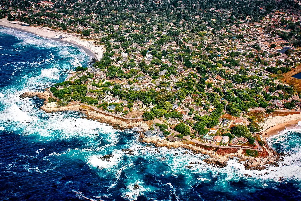 Carmel-by-the-Sea from the air: houses among trees along the rocky shore