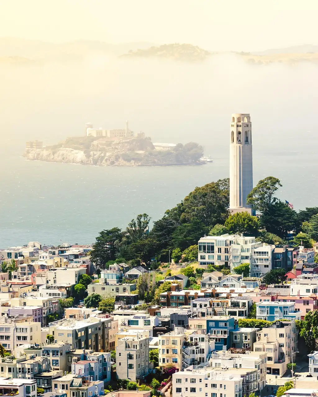 Coit Tower above North Beach, with Alcatraz in the fog
