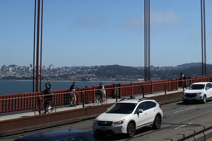 Cyclists on the Golden Gate Bridge walkway, with San Francisco behind