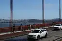 Cyclists on the Golden Gate Bridge walkway, with San Francisco behind