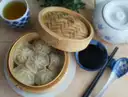 Steamed dim sum buns with tea and dipping sauce