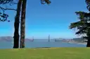 The Golden Gate Bridge seen from a park lawn on the shore