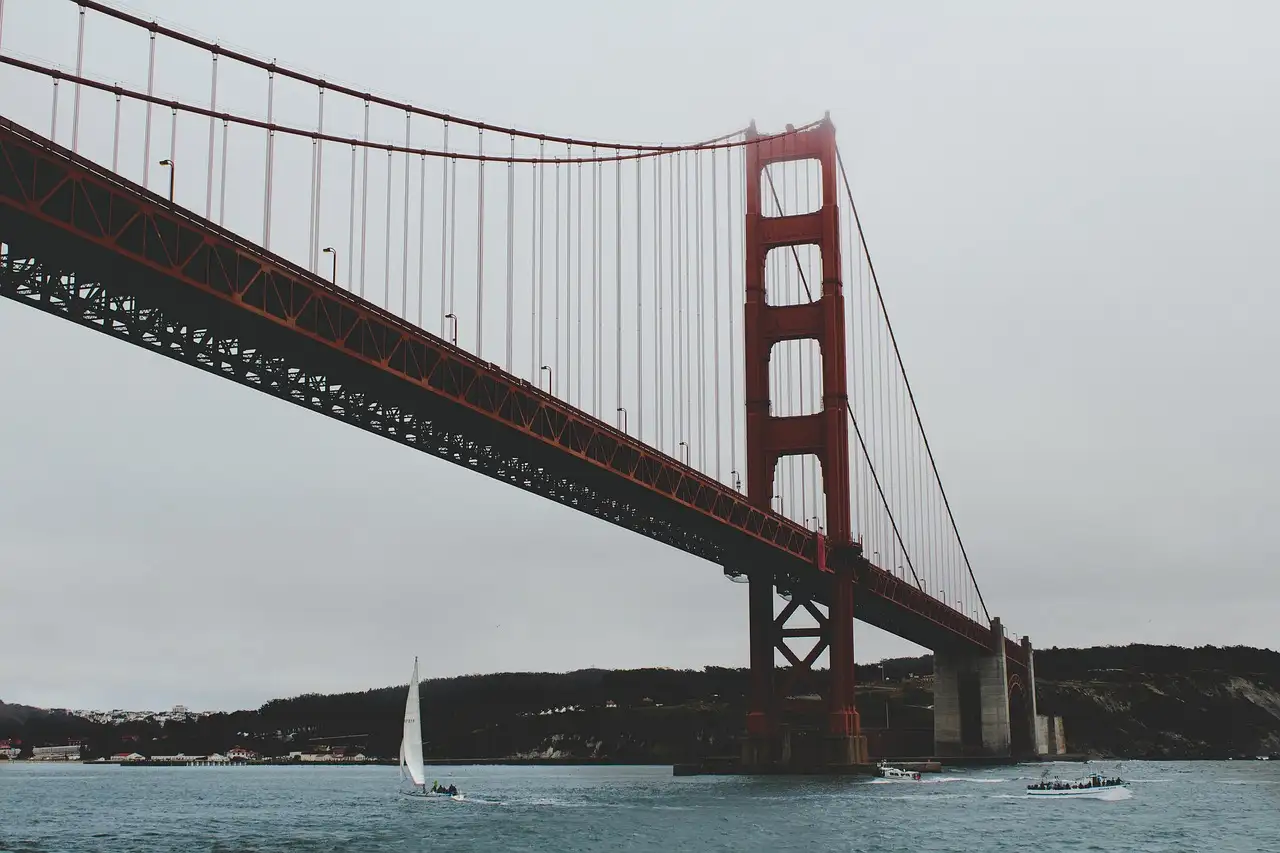 The Golden Gate Bridge seen from the water, with a sailboat beneath it