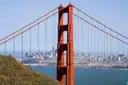 A Golden Gate Bridge tower with the San Francisco skyline across the water