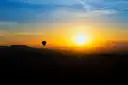 A hot air balloon over the hills of wine country at sunrise