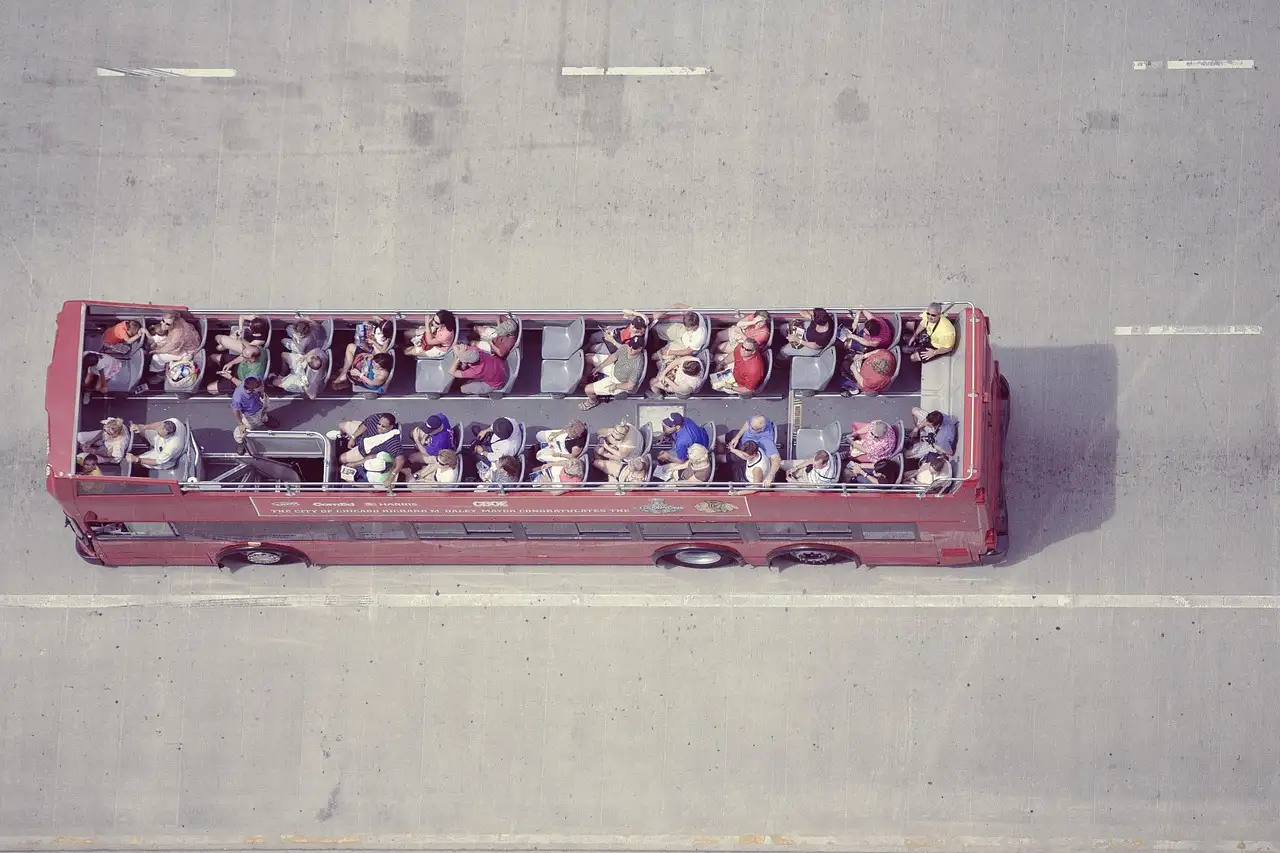 An open-top sightseeing bus full of visitors, seen from above