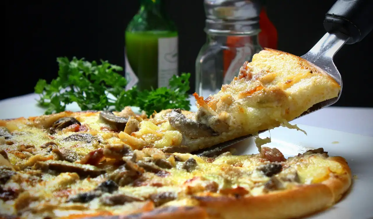 A slice of pizza being lifted from the pie