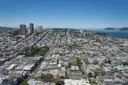 San Francisco's hills and houses from above, with the bay and fog in the distance