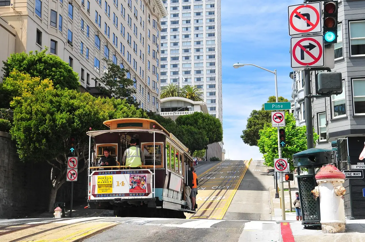 A San Francisco cable car climbing a steep street past tall buildings