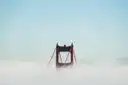 The top of a Golden Gate Bridge tower rising out of a layer of fog
