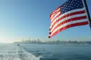 The San Francisco skyline seen from the back of a boat, with a US flag