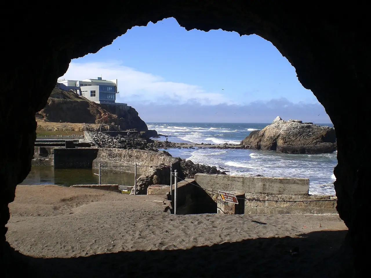 The ruins of the Sutro Baths seen from a cave opening, with the Pacific Ocean beyond