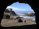 The ruins of the Sutro Baths seen from a cave opening, with the Pacific Ocean beyond